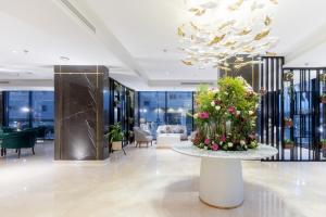 塔伊夫فندق رويال دايموند الطائف的大堂设有鲜花桌和吊灯