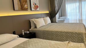 加斯帕Resort Ecoar的酒店客房设有两张床和窗户。