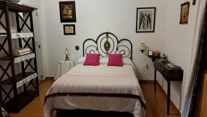 克鲁兹·德·特赫达桑塔纳塞古拉之家旅馆的卧室配有一张带粉红色枕头的大床