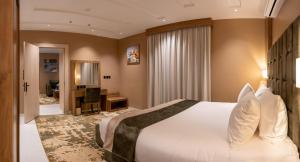 哈伊勒مستقر للشقق الفندقية الياسمين的酒店客房设有一张大床和一张书桌。