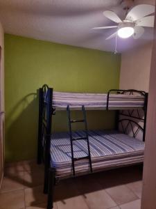 Emiliano ZapataAgusticidad en Cuernavaca的客房设有两张双层床和吊扇。