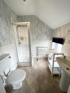 斯凯格内斯克拉伦斯酒店的带淋浴、卫生间和盥洗盆的浴室