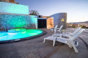 瓜纳华托Casa de Tillie的一个带白色椅子的庭院和一个游泳池