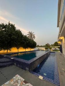 豪尔费坎ALWADI Chalet - Khorfakkan的一座建筑物边的蓝色瓷砖游泳池