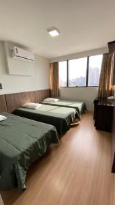 库里提巴伊塔马拉蒂酒店的客房设有三张床和大窗户