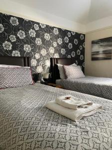 NettletonNettleton Country House的一间卧室设有两张床,并拥有黑白墙纸