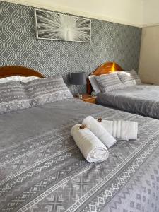 NettletonNettleton Country House的两张位于酒店客房的床,配有毛巾
