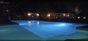卡塔尼亚La Corte Della Regina的夜间大型游泳池,灯光照亮