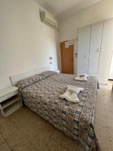 里米尼Mehari Hotel Rimini的一间卧室配有一张床,上面有两条毛巾