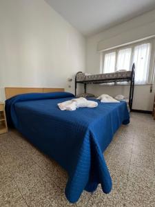 里米尼Mehari Hotel Rimini的一间卧室配有蓝色的床和毛巾