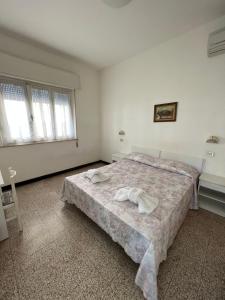里米尼Mehari Hotel Rimini的一间卧室配有一张床,上面有两条毛巾