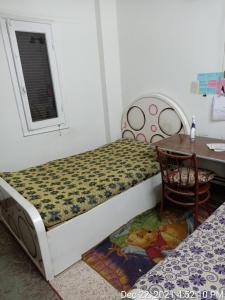 سوهاج الجديدة的一间卧室配有一张床、一张桌子和一张桌子