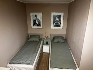 瓦拉日丁Jourek Apartment的小客房内的两张床,配有两张sidx sidx单人床
