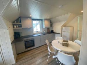FedaSouthern bliss - Sørlandsidyll的一间厨房,内设桌子和白色椅子
