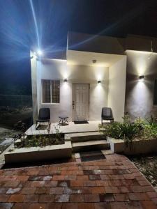 普罗维登西亚莱斯岛StoneSide Villa的白色的房子,配有两把椅子和一扇门
