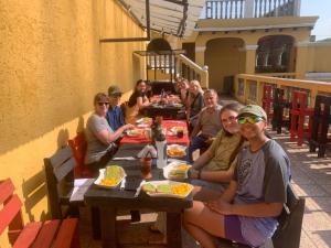 危地马拉Ciudad Vieja Bed & Breakfast Hotel的一群人坐在餐桌旁吃着食物