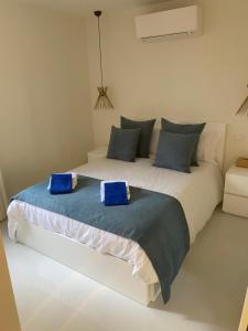 Saint-AntoineCap d ail Appartement aux portes de Monaco的卧室配有带蓝色枕头的大型白色床