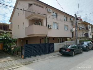 斯特鲁米察Grand Apartments Strumica的两辆车停在大楼前的建筑物