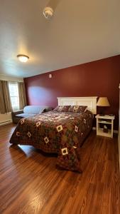 麦金利公园Denali Rainbow Village RV Park and Motel的一间卧室配有一张床和一张带台灯的桌子