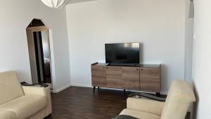 曼加利亚Central Apartment的客厅配有木梳妆台上的电视