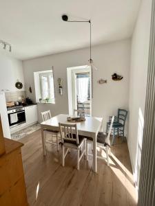 费德拉帕加内拉La mia casa di Fai petit的厨房以及带白色桌椅的用餐室。