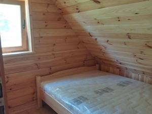 GrywałdZa Potokiem的小木屋,带一张床,位于带窗户的房间内