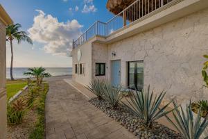 科苏梅尔The Queen of Cozumel Beach House -Luxury Beachfront Villa- MILLION DOLLARS VIEW的海滩上的房子,背景是大海