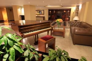 波哥大Hotel Windsor House Inn By GEH Suites的客厅配有钢琴和沙发