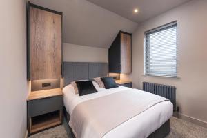 安布尔Marina West - Amble, Northumberland的卧室设有一张白色大床和一扇窗户。