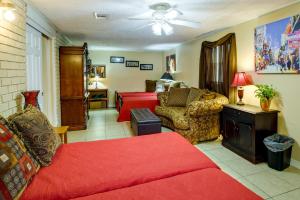 新奥尔良Quaint New Orleans Home about 10 Mi to Bourbon St!的客厅配有红色的沙发和床。