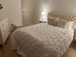 什切齐内克Premium Apartament Polna Szczecinek的卧室配有一张带白色棉被的大床