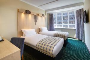 伦敦Tavistock Hotel的带窗户的客房内的两张床