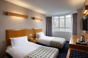 伦敦Tavistock Hotel的酒店客房设有两张床和窗户。