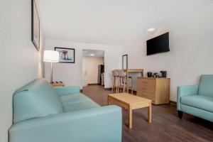 巴拿马城海滩海边城堡汽车旅馆的客厅配有2张蓝色沙发和电视