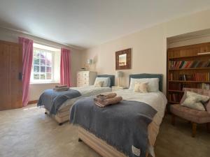 克里夫Spacious cottage - walk to Crieff的一间卧室设有两张床和书架