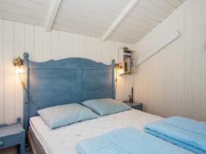 海默特Holiday home Hemmet XVII的一张带蓝色床头板的睡床