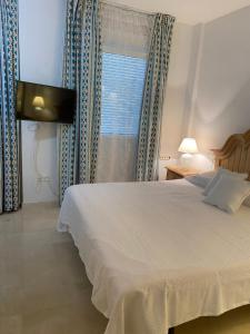 萨阿拉德洛斯阿图内斯Casa del Mar的卧室配有白色的床和窗户。