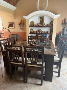 危地马拉Casa vacacional en escuintla的一间带木桌和椅子的用餐室