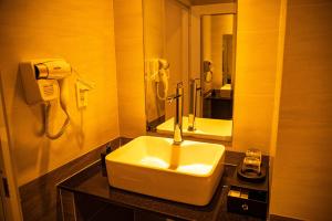 Cao Lãnh普科酒店的一间带水槽的浴室和墙上的一部电话