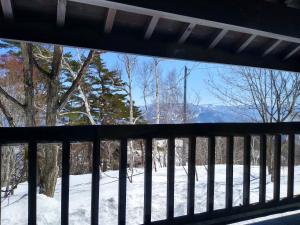 饭山市Robin's Lodge的阳台享有雪景。