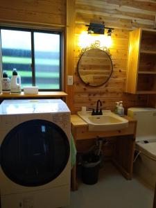 饭山市Robin's Lodge的一间带水槽的浴室和客房内的电视
