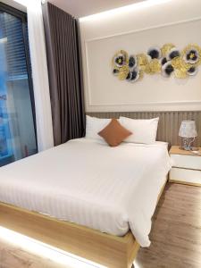 绥和市Kings House Apec Condotel Phú Yên的卧室配有白色的床和窗户。