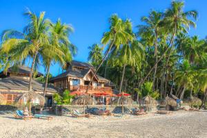 额布里佑玛樱桃旅舍的海滩上的度假村,设有椅子和棕榈树