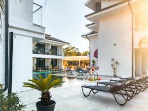费特希耶S-Cape Hotel Fethiye的享有带游泳池和躺椅的度假村外部景色