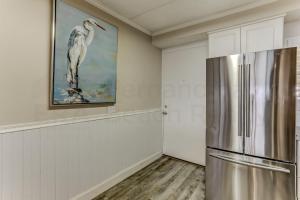 阿米莉亚岛Oceanview Upper Unit Condo的厨房配有冰箱,墙上挂有绘画作品