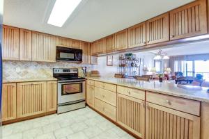费南迪纳比奇Atlantis Oceanfront Condo的厨房配有木制橱柜和炉灶烤箱。