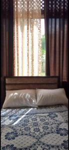 安曼Jawal Hotel的一张带两个枕头的床和一个带窗帘的窗户
