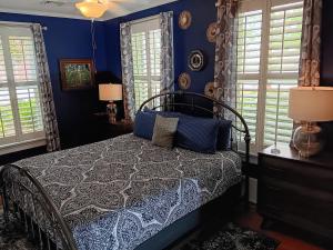 伊丽莎白城Blue Ruby at Grice-Fearing B&B的一间卧室配有一张蓝色墙壁和窗户的床