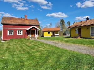于斯达尔Holiday home LJUSDAL IV的一座红色的房子和一座黄色的房子,有院子