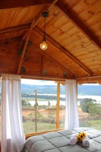 瓜塔维塔Camping & Cabaña San Francisco - Guatavita的一间卧室设有一张床和一个大窗户